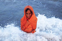 
	یک زن هندو در حال عبادت خدای خورشید در سواحل بمبئی.

